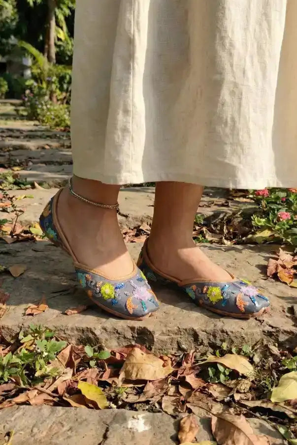 Person wearing floral flats on a stone path with a natural background